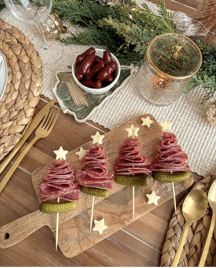Festive charcuterie skewers with salami, cheese stars, and gherkins on a holiday table setting.