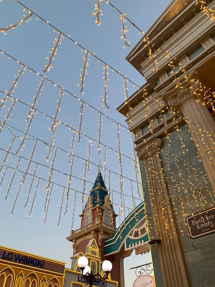 vibe Tashkent Festive lights adorn a theme park's towers and columns under a clear sky, creating a magical evening ambiance. | Sky Rye Design Festive lights adorn a theme park's towers and columns under a clear sky, creating a magical evening ambiance.