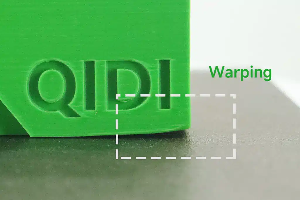 warping_1024x1024_e40afd04-7831-4a33-beaf-42d0d7806a55 Close-up of green 3D print with QIDI text, highlighting warping issue at the edge with a dashed box. | Sky Rye Design Close-up of green 3D print with QIDI text, highlighting warping issue at the edge with a dashed box.