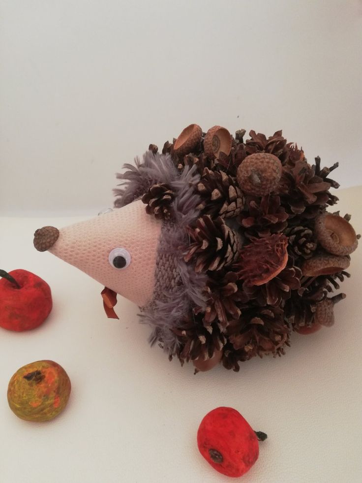 Осіння композиція їжачок з природних матеріалів Crafted hedgehog made of acorns and pinecones with painted apples on a light background. | Sky Rye Design Crafted hedgehog made of acorns and pinecones with painted apples on a light background.