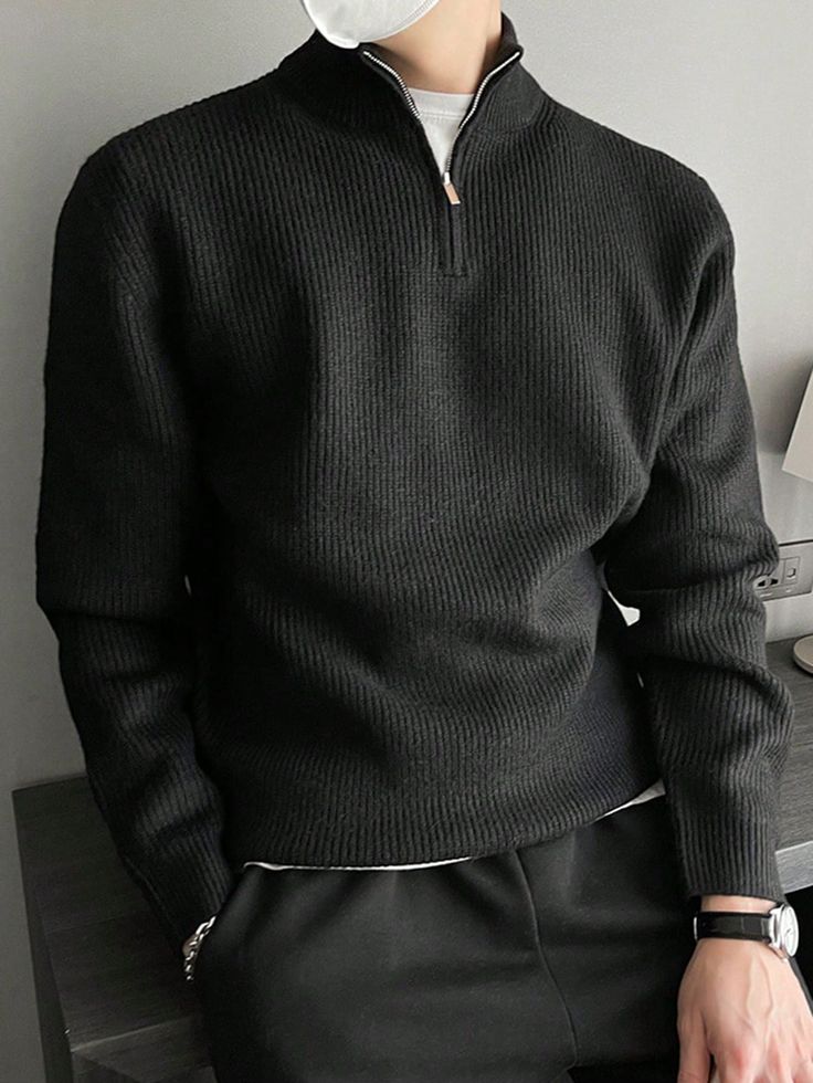 リブニット クォータージップ セーター メンズ秋冬ウェア Man wearing a black ribbed sweater and a watch, casually leaning on a table. | Sky Rye Design Man wearing a black ribbed sweater and a watch, casually leaning on a table.