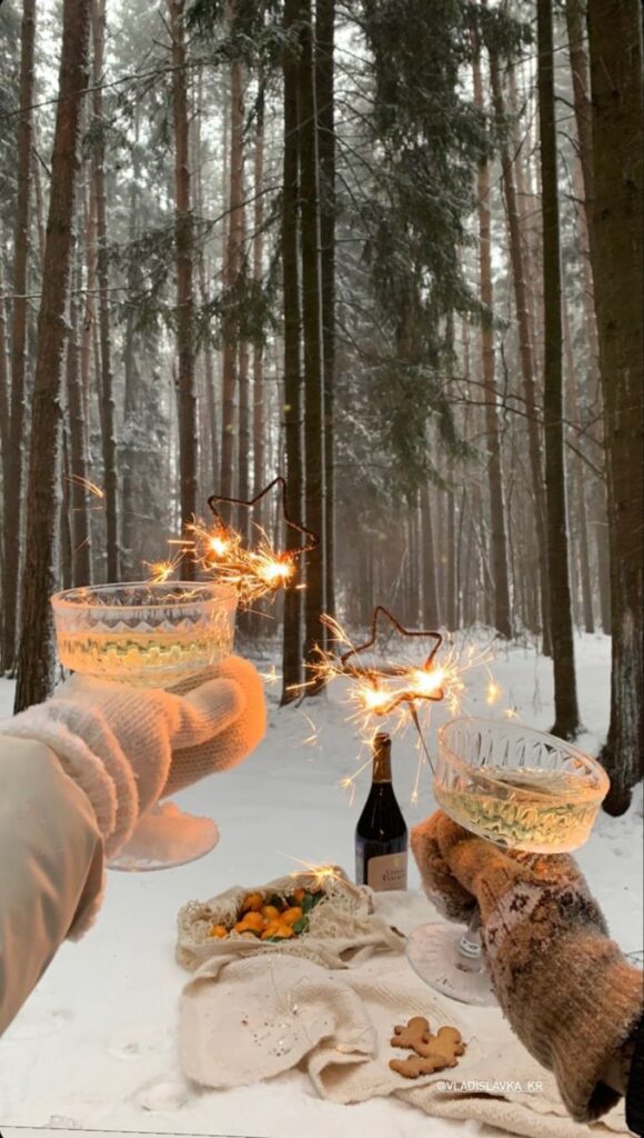 🥂 Two people toasting with sparklers in a snowy forest, enjoying a cozy winter picnic with wine and snacks. | Sky Rye Design Two people toasting with sparklers in a snowy forest, enjoying a cozy winter picnic with wine and snacks.