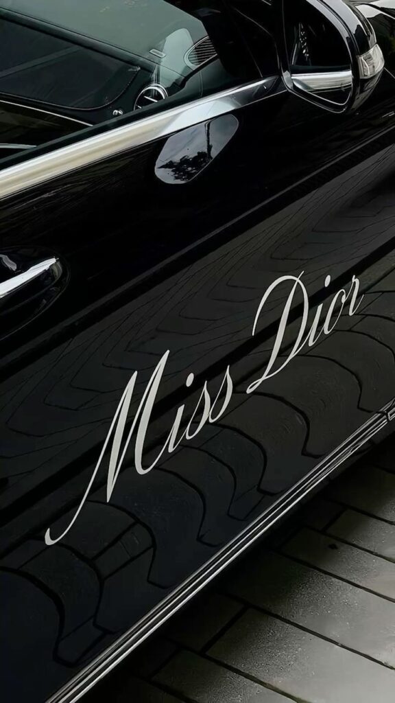 явпиявы Close-up of a black car door with Miss Dior elegantly scripted on it, reflecting luxury and style. | Sky Rye Design Close-up of a black car door with Miss Dior elegantly scripted on it, reflecting luxury and style.