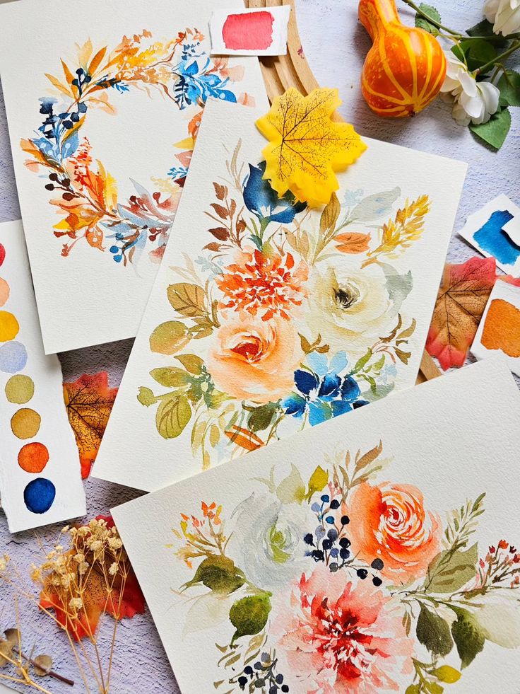 Floral watercolor paintings with vibrant autumn leaves and color samples, featuring orange, blue, and yellow hues on textured paper.