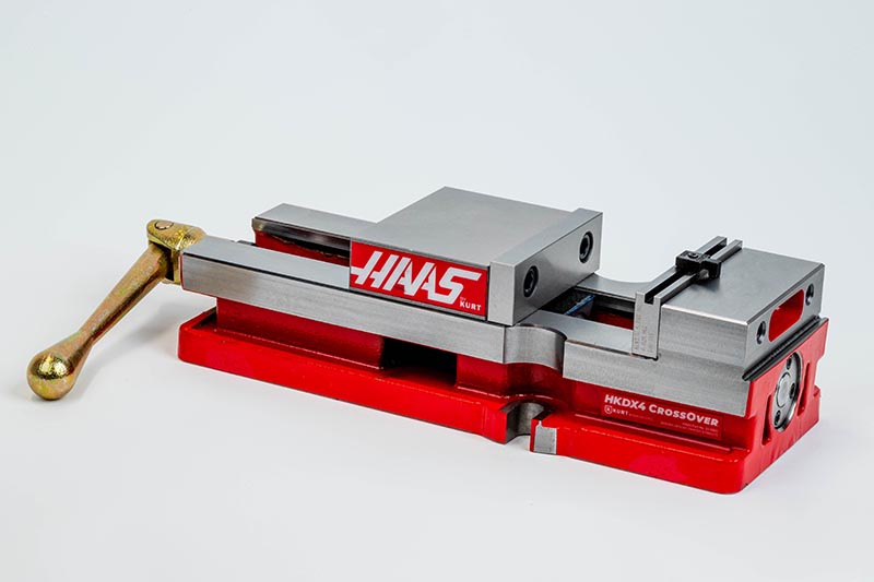 05-0405 Precision machine vise with red base and gold handle, branded HAAS for CNC machining applications. | Sky Rye Design Precision machine vise with red base and gold handle, branded HAAS for CNC machining applications.