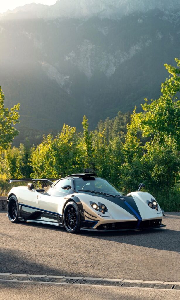 05f6924db378522fc639a880b567cac4 Silver sports car parked on a scenic road with lush greenery and mountains in the background, under a sunlit sky. | Sky Rye Design Silver sports car parked on a scenic road with lush greenery and mountains in the background, under a sunlit sky.