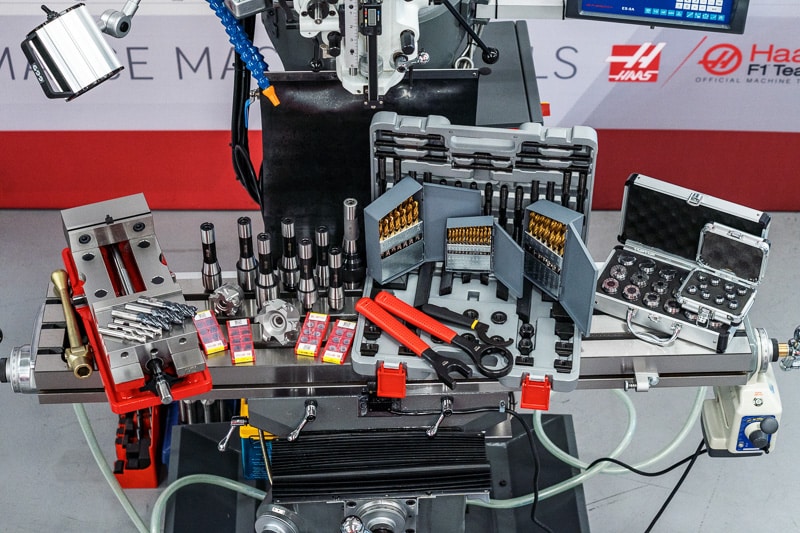 08-2029 Machining tools and accessories on a metal milling machine table in an industrial workshop setting. | Sky Rye Design Machining tools and accessories on a metal milling machine table in an industrial workshop setting.
