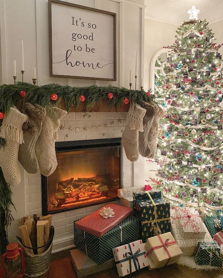 _ 1 Cozy Christmas living room with decorated tree, gifts, stockings, and fireplace. Sign reads It's so good to be home. | Sky Rye Design Cozy Christmas living room with decorated tree, gifts, stockings, and fireplace. Sign reads It's so good to be home.