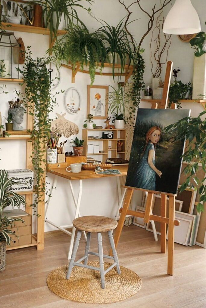 Cozy artist studio with easel, painting, plants, and wooden furniture. Creative workspace with natural light and warm, inviting decor.