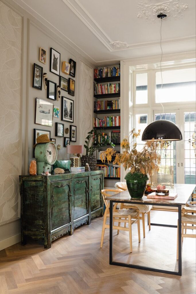 _ 10 Stylish dining room with vintage decor, green cabinet, and wall art, featuring a wooden floor and bookshelf. | Sky Rye Design Stylish dining room with vintage decor, green cabinet, and wall art, featuring a wooden floor and bookshelf.