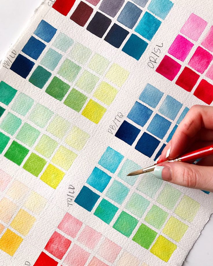 Hand painting vibrant watercolor swatches on textured paper, showcasing a variety of hues and shades. Perfect for art and design inspiration.