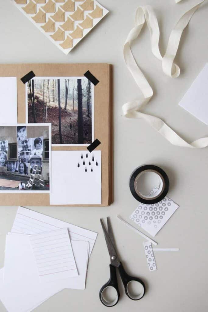 Scrapbooking materials with photos, washi tape, scissors, and paper on a desk, perfect for creative DIY projects and inspiration.