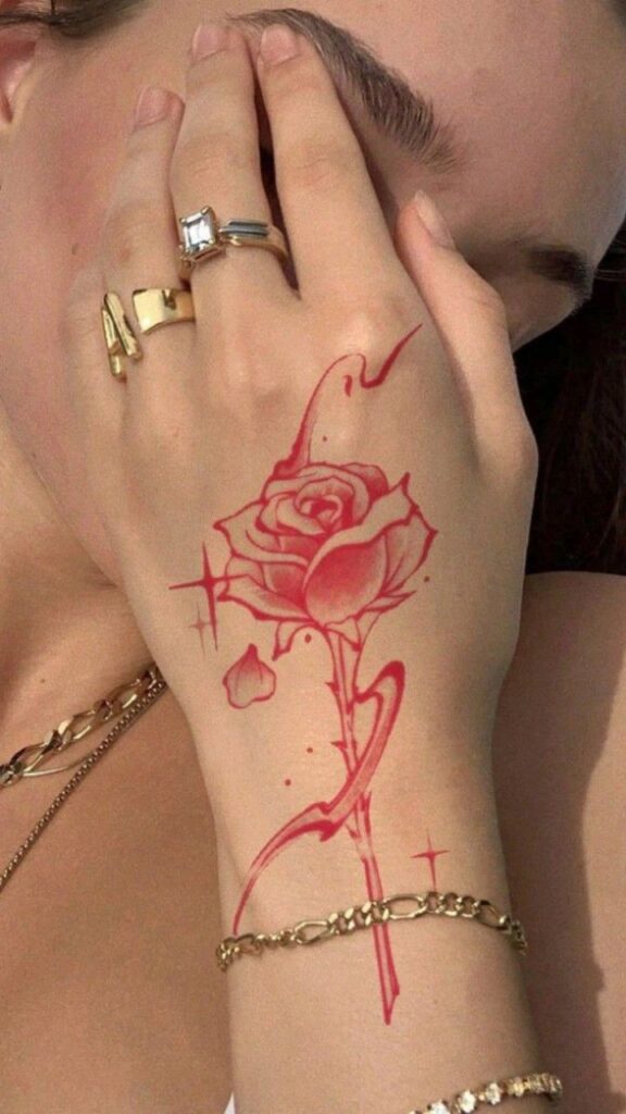 10bd048cd95f605accd385dcd011c5b1 Elegant hand with rose tattoo, adorned with gold rings and bracelets, showcasing unique artistic style. | Sky Rye Design Elegant hand with rose tattoo, adorned with gold rings and bracelets, showcasing unique artistic style.