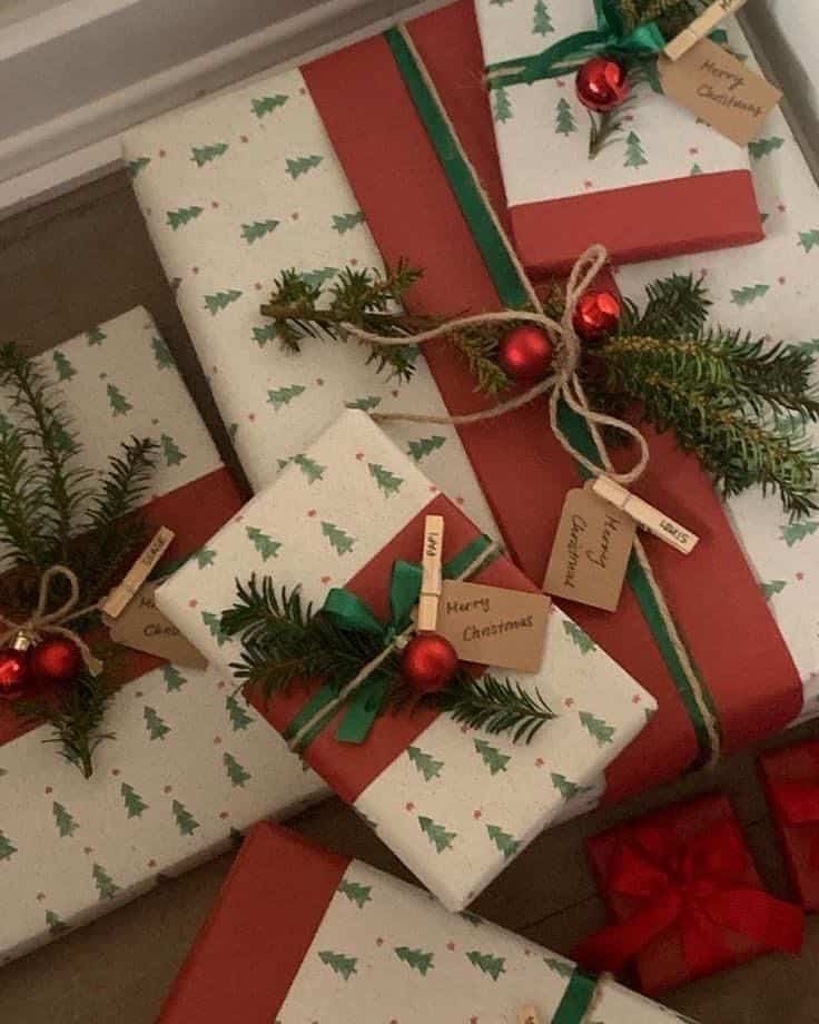 _ 11 Festive Christmas presents wrapped in green and red paper with tree patterns, adorned with small pine branches and red baubles. | Sky Rye Design Festive Christmas presents wrapped in green and red paper with tree patterns, adorned with small pine branches and red baubles.