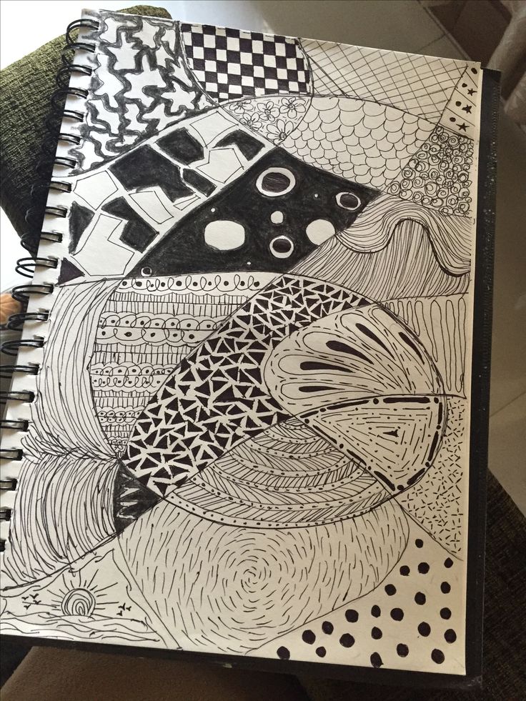 Black and white sketched doodles fill a spiral notebook, featuring diverse patterns and abstract designs.