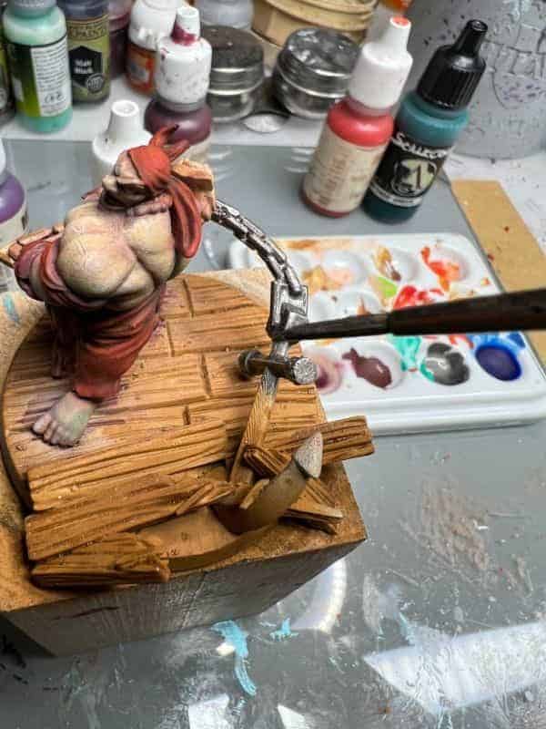 12b0a72f556b51180499e98ab17ed0e8 Miniature figure being painted on a wooden base, surrounded by model paints and brushes. | Sky Rye Design Miniature figure being painted on a wooden base, surrounded by model paints and brushes.
