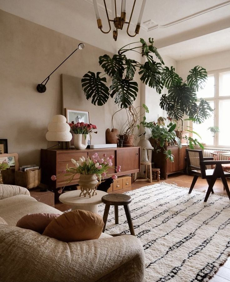 _ 13 Cozy living room with lush plants, modern furniture, and warm lighting, creating a serene, inviting atmosphere. | Sky Rye Design Cozy living room with lush plants, modern furniture, and warm lighting, creating a serene, inviting atmosphere.