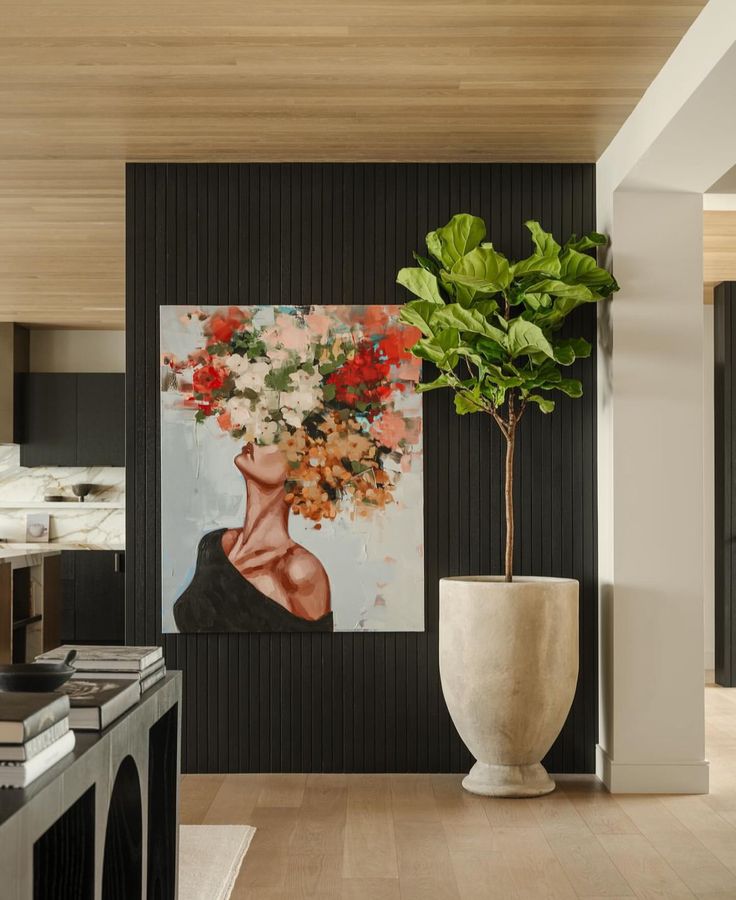_ 13 Painting of a woman with floral head next to a large potted plant in a modern, stylish living space. | Sky Rye Design Painting of a woman with floral head next to a large potted plant in a modern, stylish living space.