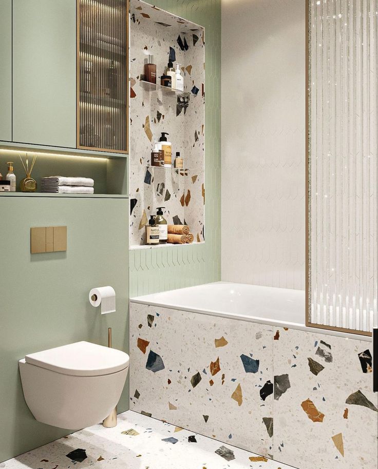 Modern bathroom with terrazzo accents, green cabinetry, and stylish decor for a chic, minimalist look.