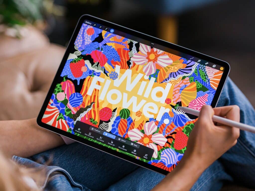 14454203052024_accf102caaa970ce65d217b9ae9a8e9a57caa67c Person using a stylus to create colorful floral artwork on a tablet screen displaying Wild Flower text. | Sky Rye Design Person using a stylus to create colorful floral artwork on a tablet screen displaying Wild Flower text.