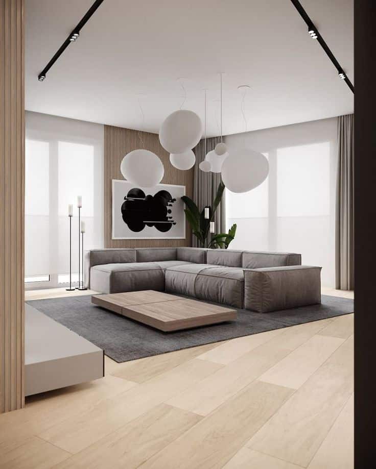 _ 15 Modern living room with gray sectional sofa, abstract art, pendant lights, and wood accents. | Sky Rye Design Modern living room with gray sectional sofa, abstract art, pendant lights, and wood accents.
