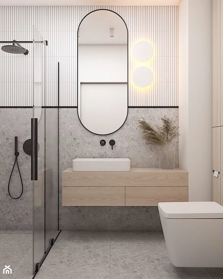 Modern bathroom with oval mirror, floating vanity, rainfall shower, and stylish stone tiles. Minimalist design.