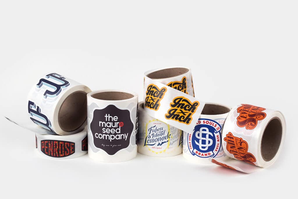 1517661983-Auto-Roll-Stickers_3 A collection of branded sticker rolls featuring colorful logos on a white background, showcasing custom design and printing services. | Sky Rye Design A collection of branded sticker rolls featuring colorful logos on a white background, showcasing custom design and printing services.