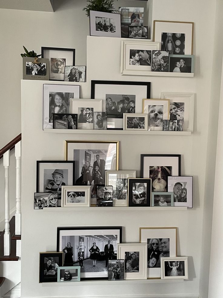 A staircase wall adorned with various framed black-and-white family photos, showcasing cherished memories and a cozy home atmosphere.