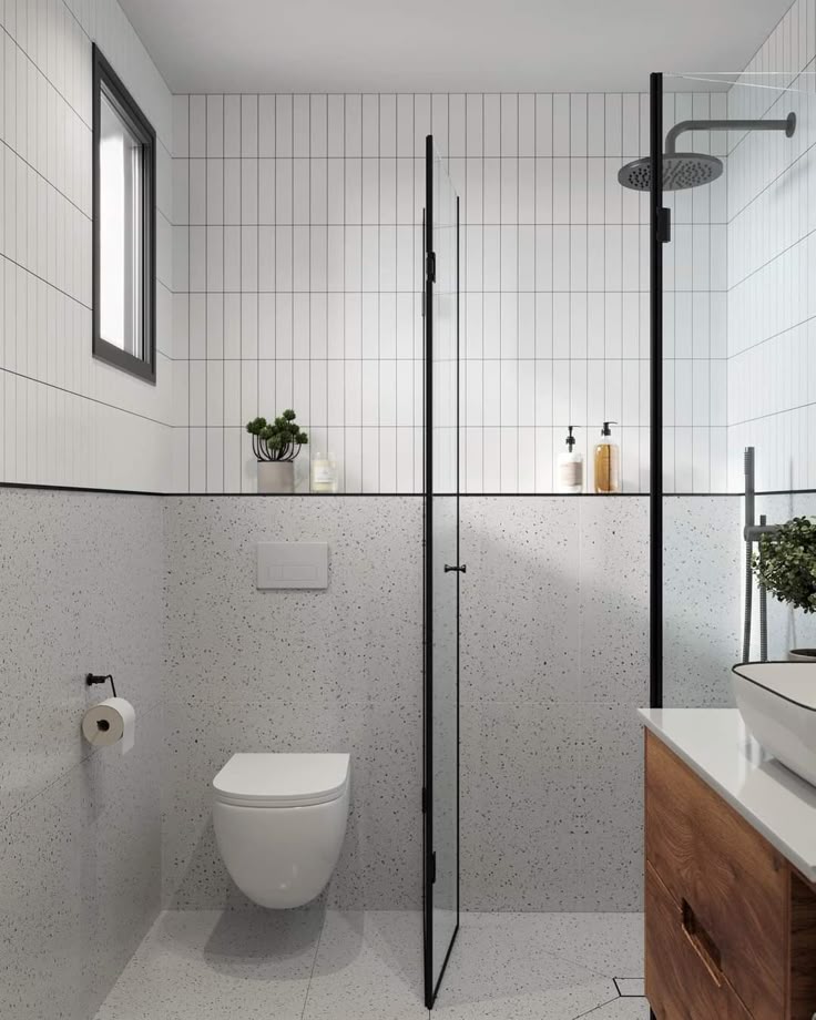 Modern bathroom with glass shower, wall tiles, and wooden vanity for a sleek, minimalist design.