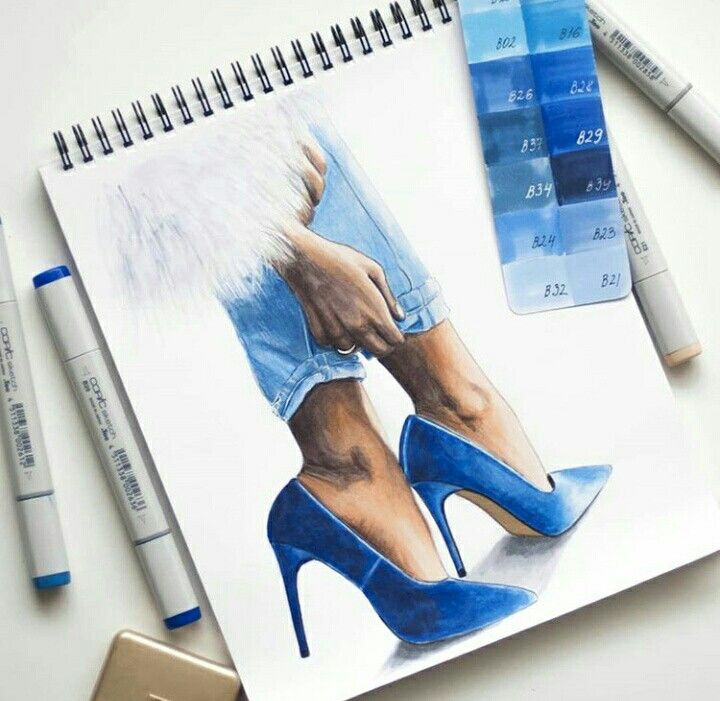 Sketch of legs in blue high heels with color swatches on a spiral sketchbook, surrounded by blue markers.