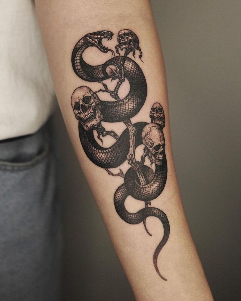 Forearm tattoo of a coiled snake entwined with skulls, showcasing intricate details and a dark, gothic design.