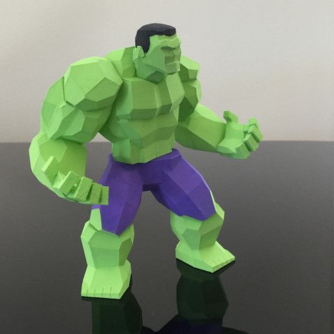 Green superhero paper figure in a low-poly style, standing on a reflective surface, showcasing muscular build and purple shorts.