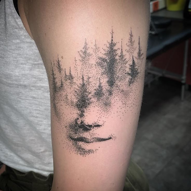 Dotwork tattoo of a face and trees on arm, blending art and nature in intricate detail.