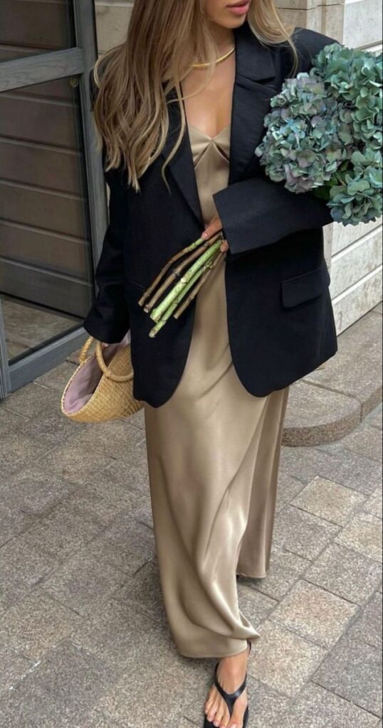 _ 20 Stylish woman in a satin dress and black blazer holds hydrangeas while carrying a straw bag, showcasing chic summer fashion. | Sky Rye Design Stylish woman in a satin dress and black blazer holds hydrangeas while carrying a straw bag, showcasing chic summer fashion.