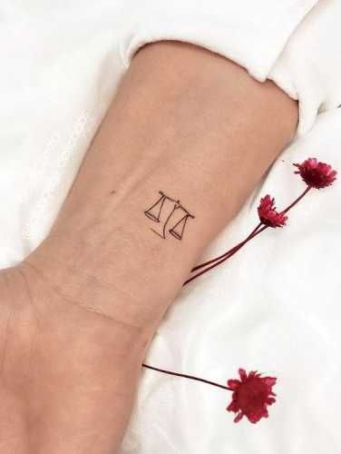 20 Psychology Tattoo Minimalist Ideas_ Mindful Ink for the Thoughtful Libra symbol tattoo on wrist with red flowers on white background. | Sky Rye Design Libra symbol tattoo on wrist with red flowers on white background. Considering a subtle design? Explore our guide to professional and easy tattoo ideas. Find minimalist, meaningful, and stylish options perfect for your first ink. Easy Tattoo Ideas