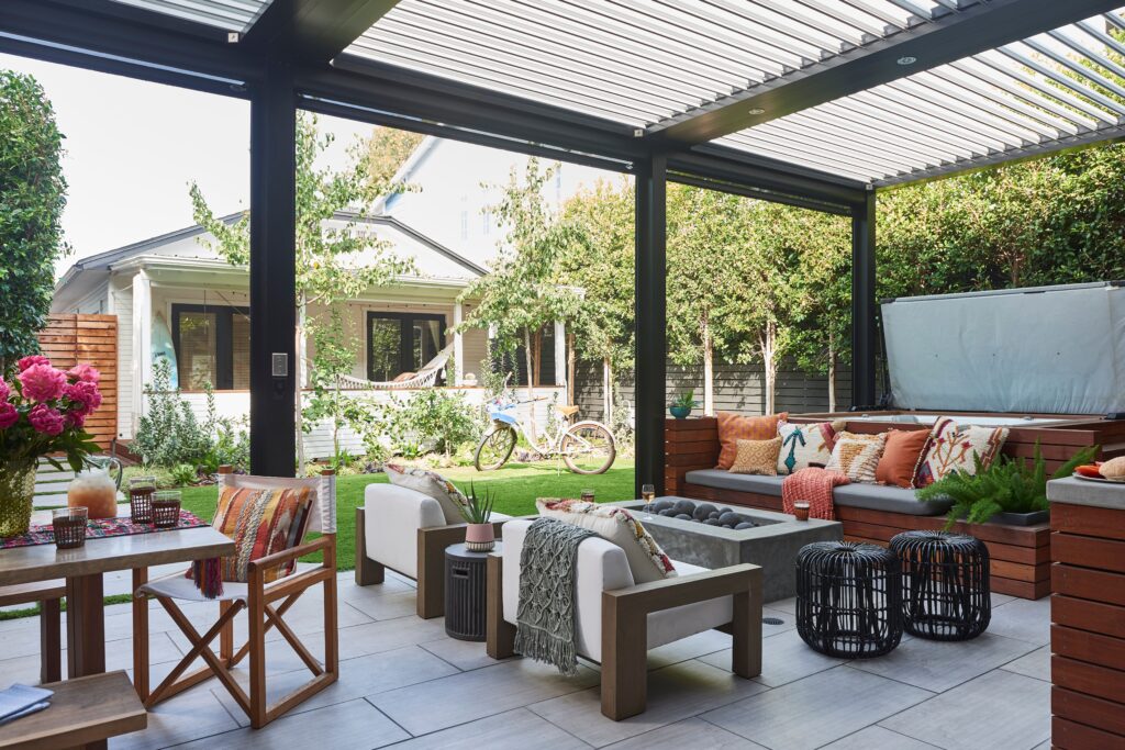 Modern patio with cozy seating, vibrant pillows, a fire pit, and garden view. Outdoor oasis perfect for relaxation and entertaining.