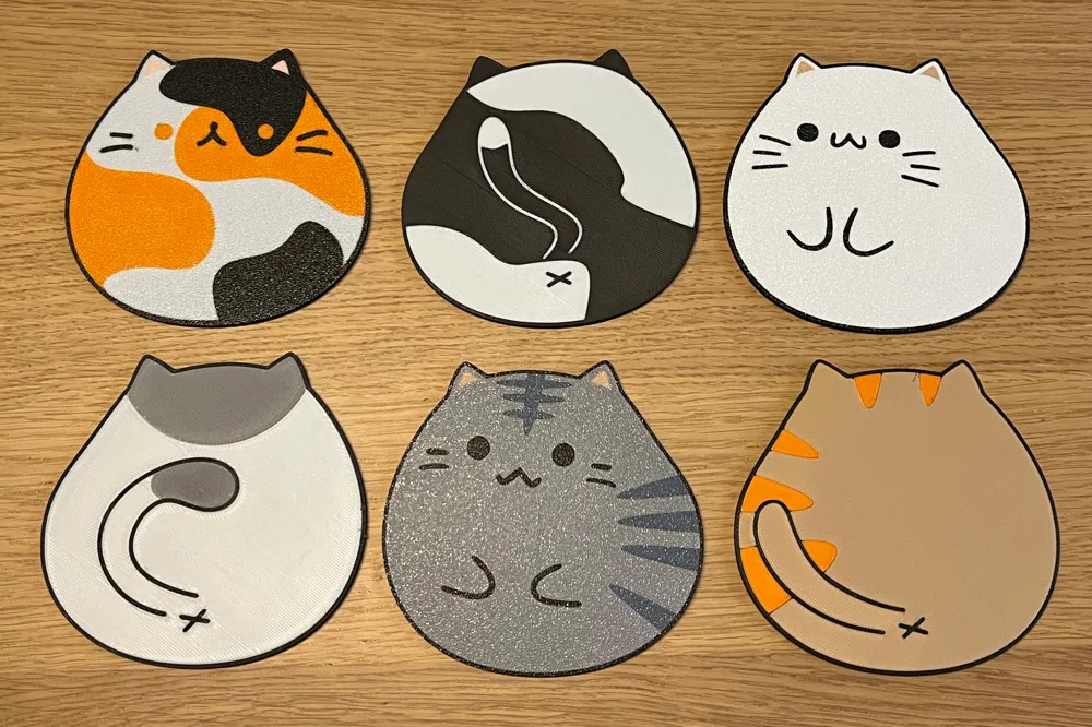 Cute cat-shaped coasters in various colors arranged on a wooden table. Perfect for adding a playful touch to your home decor.