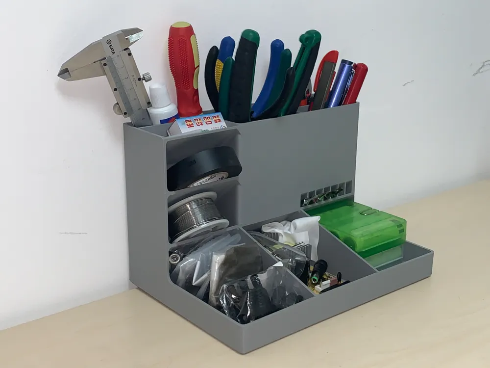 Multi-compartment organizer holding tools, tape, and office supplies on a desk, ideal for efficient workspace organization.
