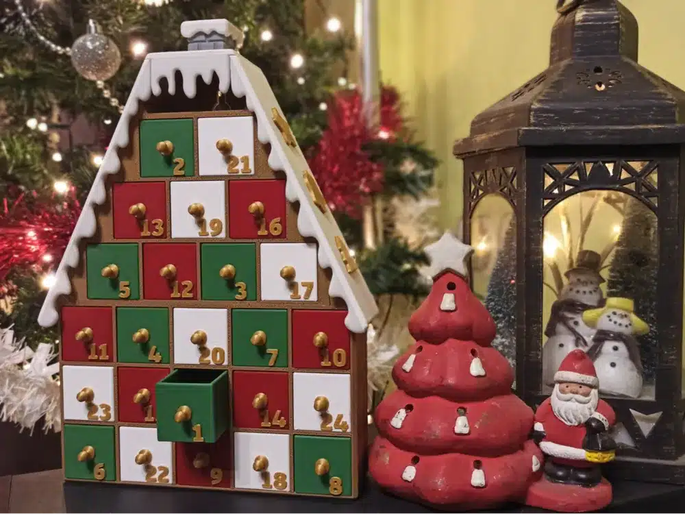 2024-11-21_d05ecea85bb94 Christmas scene with a festive Advent calendar, Santa figurine, and decorative lantern, set by a twinkling Christmas tree. | Sky Rye Design Christmas scene with a festive Advent calendar, Santa figurine, and decorative lantern, set by a twinkling Christmas tree.