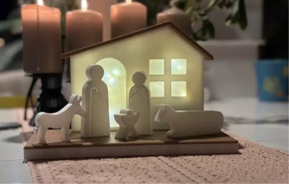 2024-12-15_8b0d0e5eca9e4 Simple nativity scene figurines in front of illuminated stable, with candles in the background, creating a warm, festive ambiance. | Sky Rye Design Simple nativity scene figurines in front of illuminated stable, with candles in the background, creating a warm, festive ambiance.