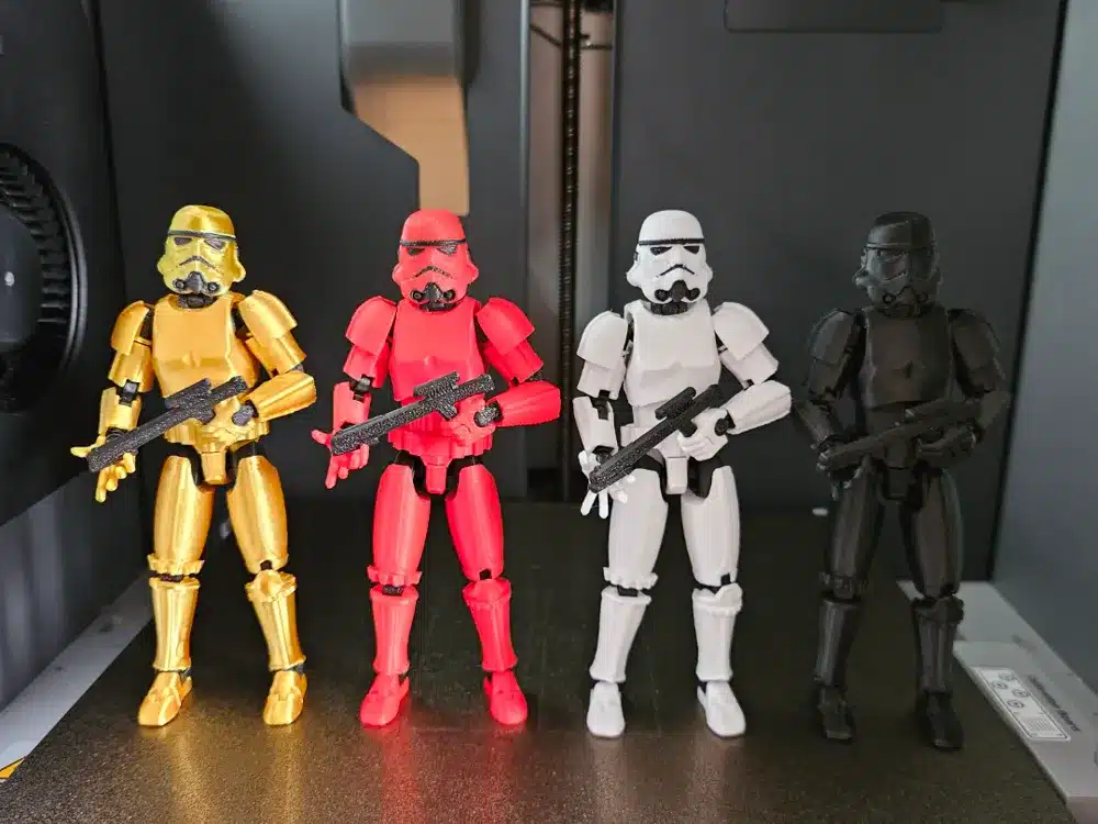 2025-01-03_d4c4b1a4dfbfd Four colorful Stormtrooper action figures in gold, red, white, and black stand in a row with weapons. | Sky Rye Design Four colorful Stormtrooper action figures in gold, red, white, and black stand in a row with weapons.
