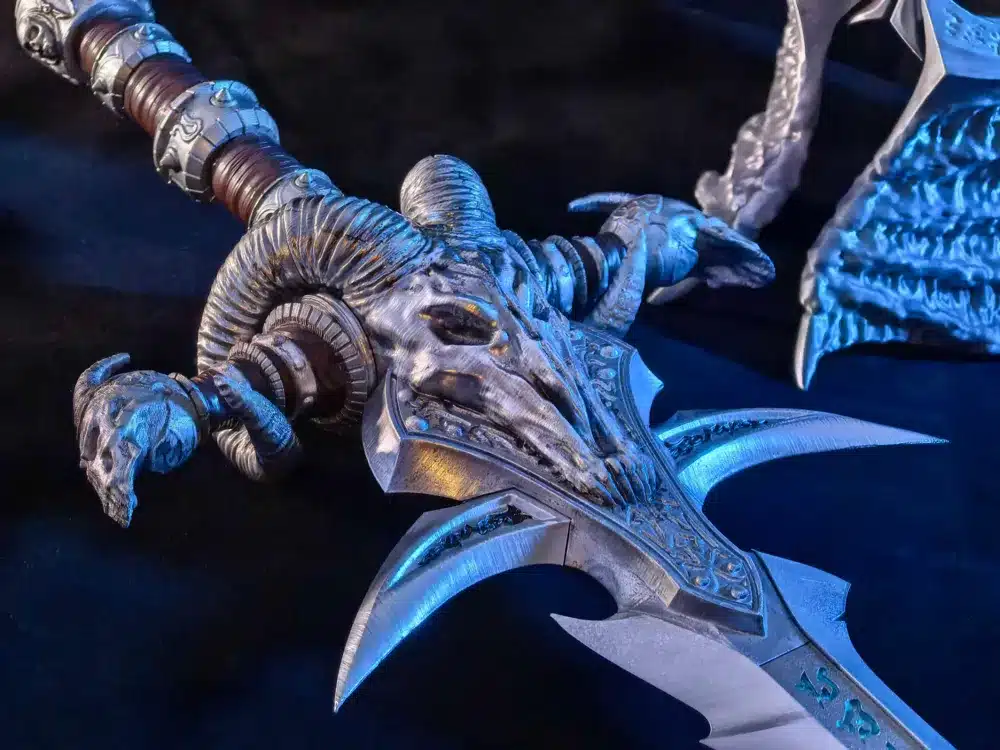 Ornate fantasy sword with horned skull hilt, intricate blade design, set against a dark background with blue lighting.