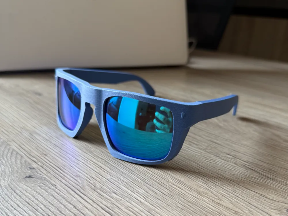 Stylish blue-framed sunglasses with reflective lenses resting on a wooden surface, ideal for fashion and sun protection.