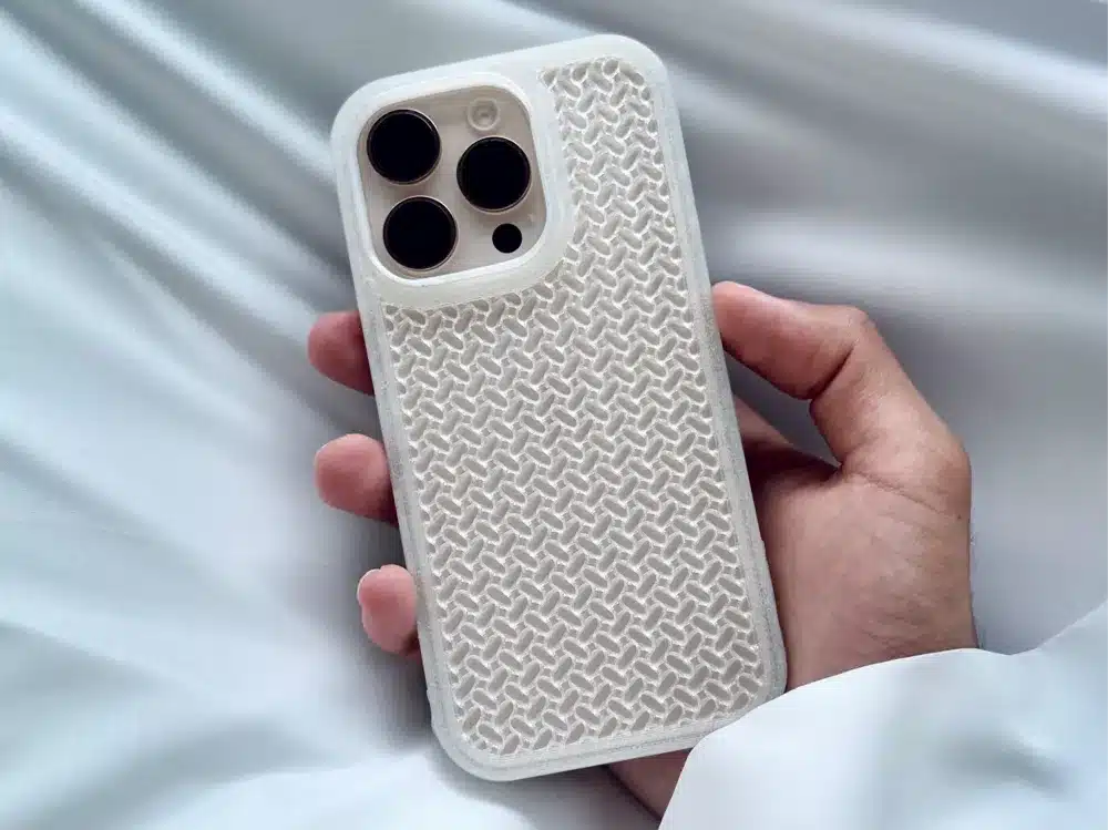 Person holding an iPhone with a textured white case, showcasing a modern design. Perfect protection and style for mobile devices.
