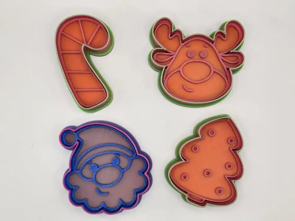 Christmas cookie cutters in festive shapes: candy cane, reindeer, Santa face, and tree, perfect for holiday baking and decorating.