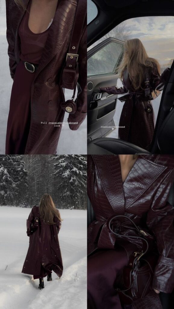 Woman in stylish maroon faux leather trench coat exploring snowy landscape and entering car, fashionably accessorized.