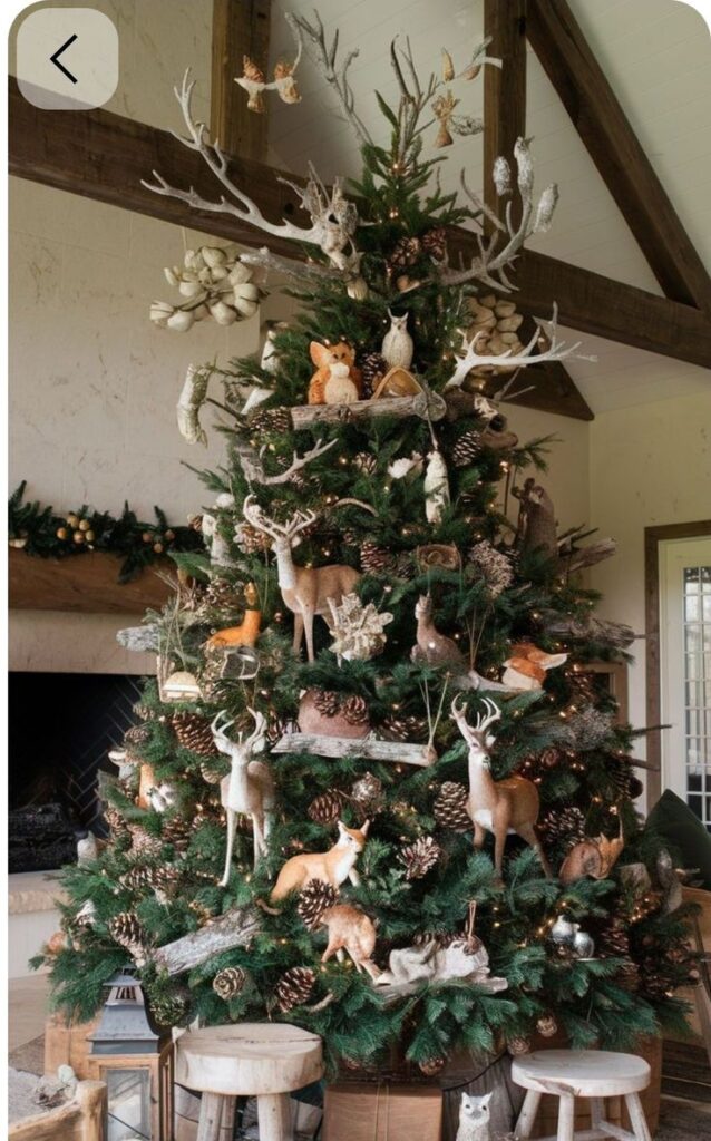 Rustic Christmas tree adorned with woodland animal decorations, pinecones, and antlers, creating a cozy, festive atmosphere indoors.