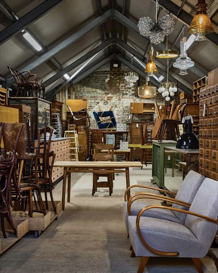 Screenshot Vintage furniture and decor in a cozy attic space, featuring chairs, tables, and unique lighting fixtures. | Sky Rye Design Vintage furniture and decor in a cozy attic space, featuring chairs, tables, and unique lighting fixtures.