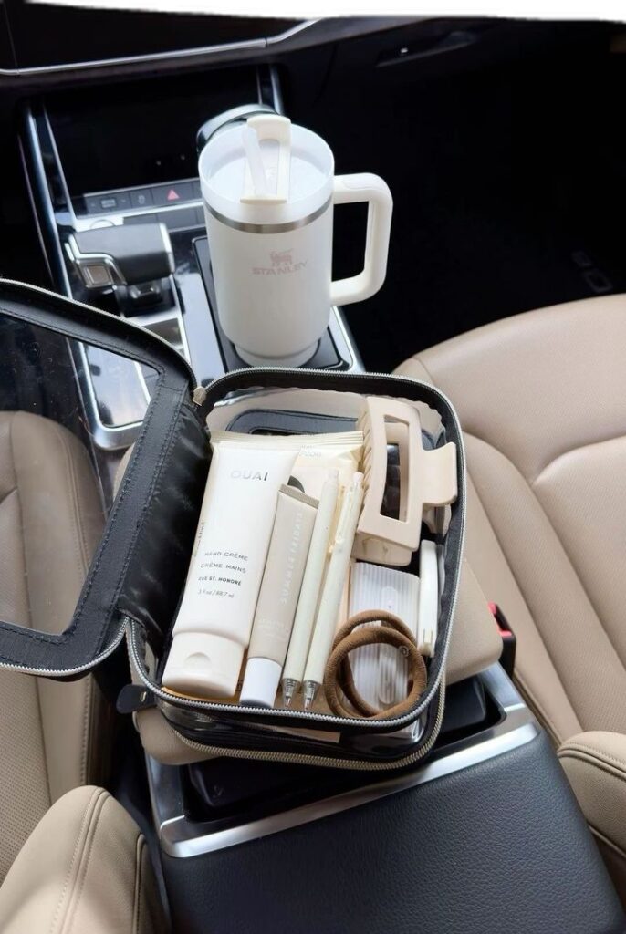 Travel essentials in car with skincare items and a reusable mug in the front seat. Perfect for on-the-go refreshment.