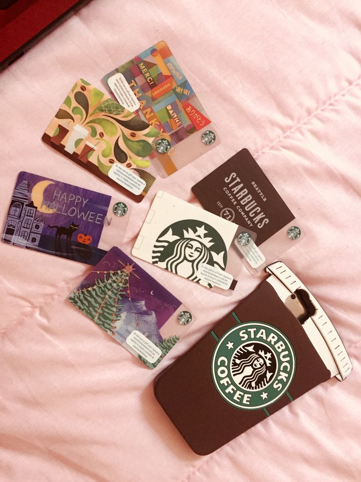 21edb677-306b-460d-bcd5-1bd5743b0b1a Assorted Starbucks gift cards with various designs and a coffee-themed phone case laid out on a pink surface. | Sky Rye Design Assorted Starbucks gift cards with various designs and a coffee-themed phone case laid out on a pink surface.